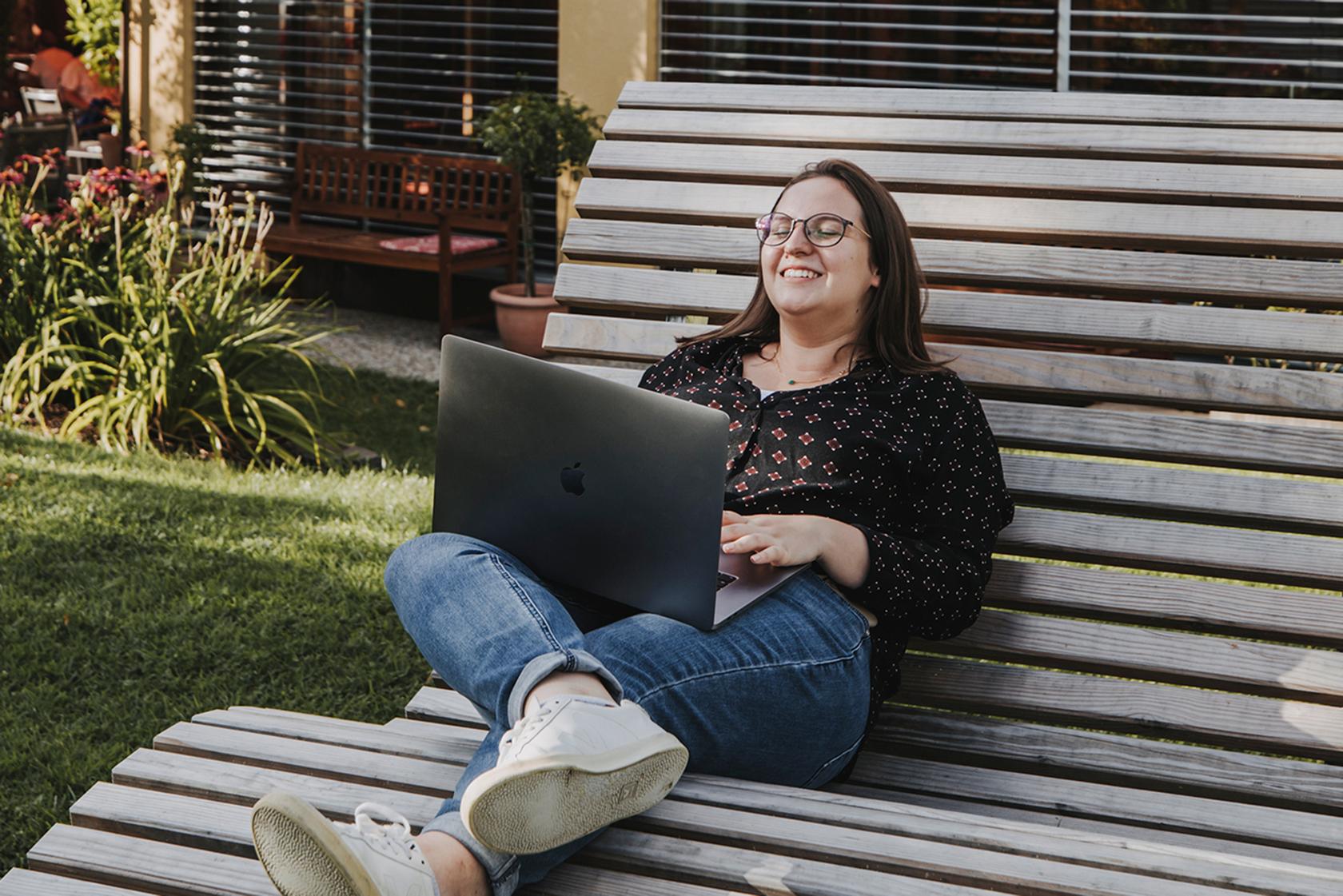 Katharina Ladurner mit Laptop im Garten der Hotels